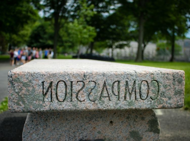 A marble outdoor bench with "Compassion" engraved in it